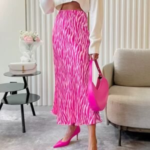 woman wearing colorful zebra skirt and pink heels, she is holding a pink purse, beige furniture in the background