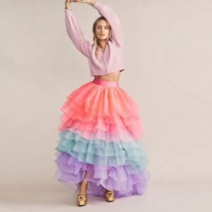 woman wearing fancy colorful skirt and a light pink blouse, she is lifting her hands up, beige background