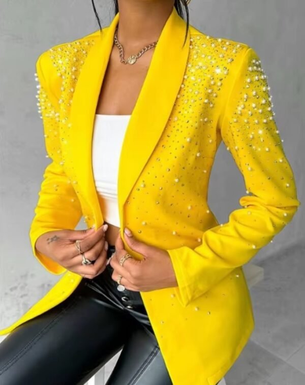 woman wearing female yellow blazer, white top and black pants, grey background