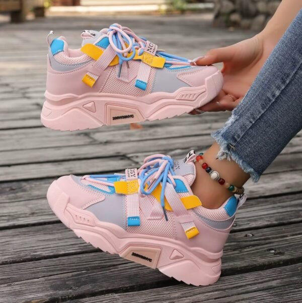 woman wearing girly colorful sneakers and holding them