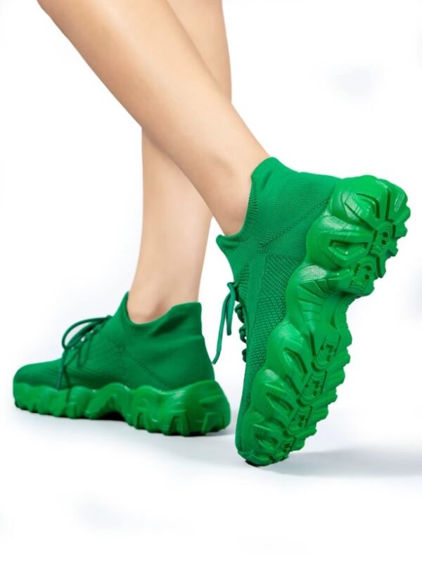 woman turned to her back wearing green sneakers for women