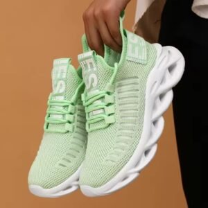 woman holding mint sneakers on the orange background