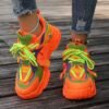 woman wearing neon colorful sneakers, colorful ankle bracelets and grey jeans, dark brown wood under her