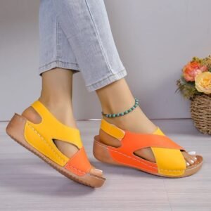 woman wearing open toe colorful sandals and blue ankle bracelet, grey wall in the background