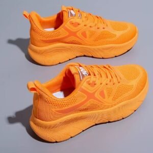 orange sneakers for women on the grey background