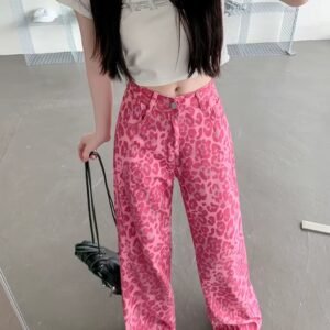 woman with black hair wearing pink leopard print pants, white top and white sneakers