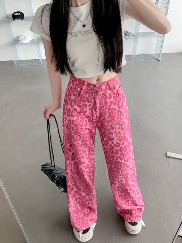 woman with black hair wearing pink leopard print pants, white top and white sneakers