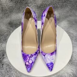 front view of purple floral heels on a white stool
