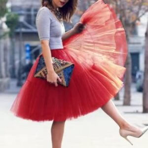 woman wearing red colorful evening skirt and holding its material, the street in the background