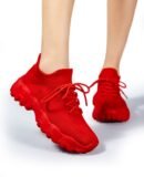 woman wearing red sneakers for women and lifting one foot up