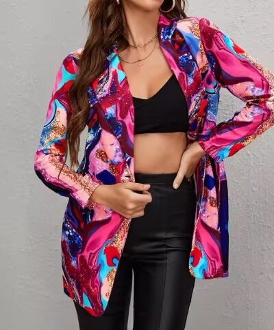 woman wearing shiny colorful blazer, a black top and black pants, grey background