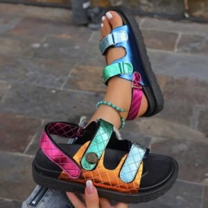 woman holding one of sporty colorful sandals and wearing the other one