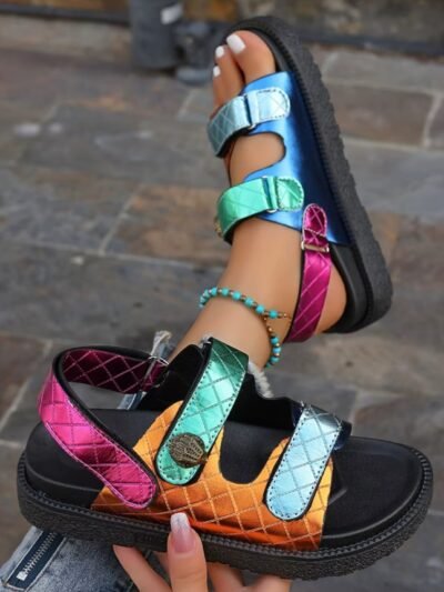 woman holding one of sporty colorful sandals and wearing the other one