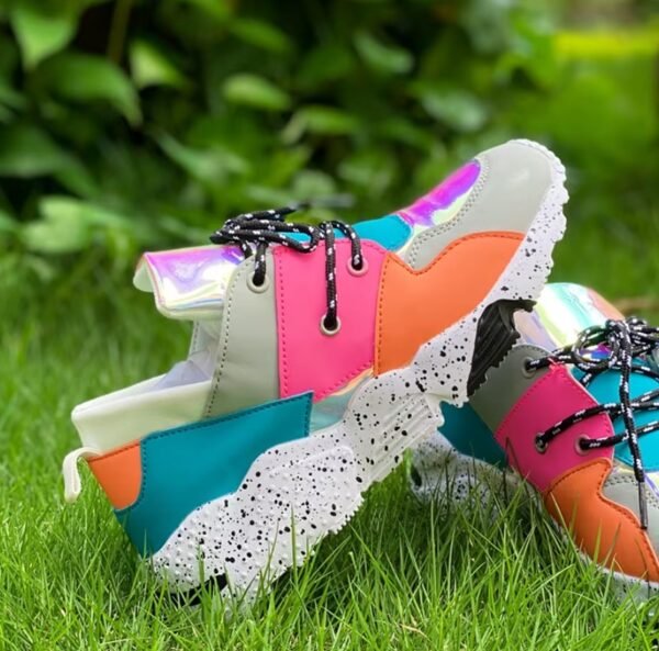 sporty colorful sneakers lying on each other on the grass