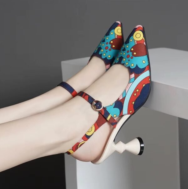 woman wearing unique colorful heels on a grey stool