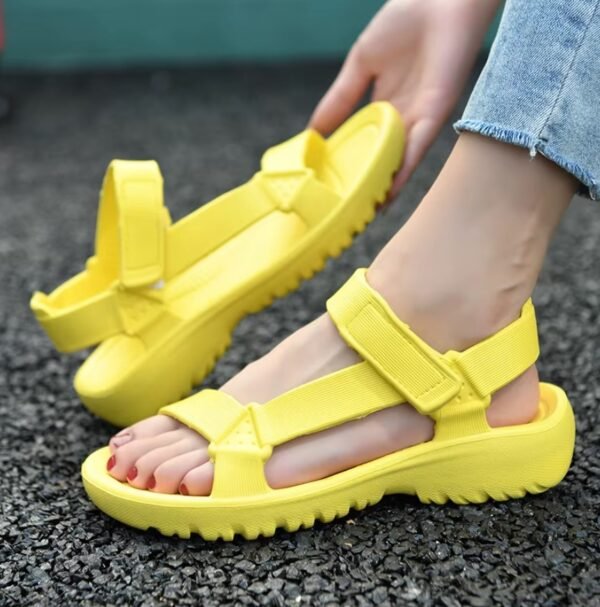 woman wearing one of yellow sandals and holding the other one