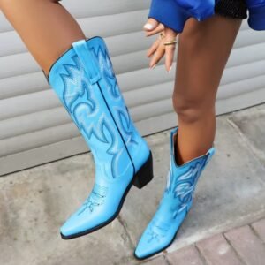 woman wearing blue cowboy boots and lifting one leg up