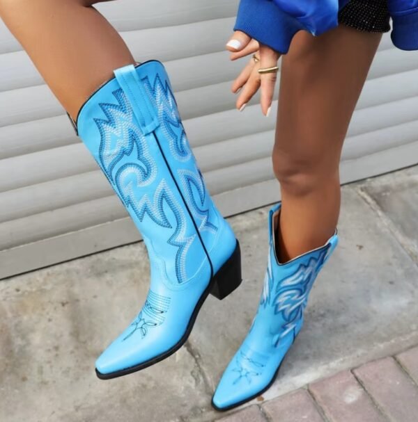 woman wearing blue cowboy boots and lifting one leg up