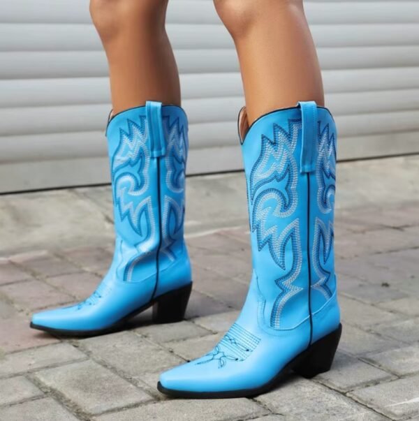 woman wearing blue cowboy boots on the grey concrete