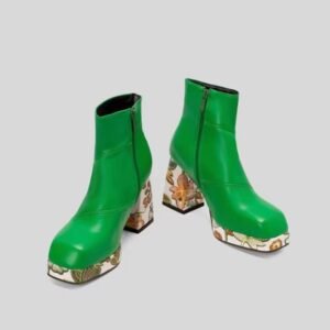 front view of green colorful Chelsea boots on the grey background