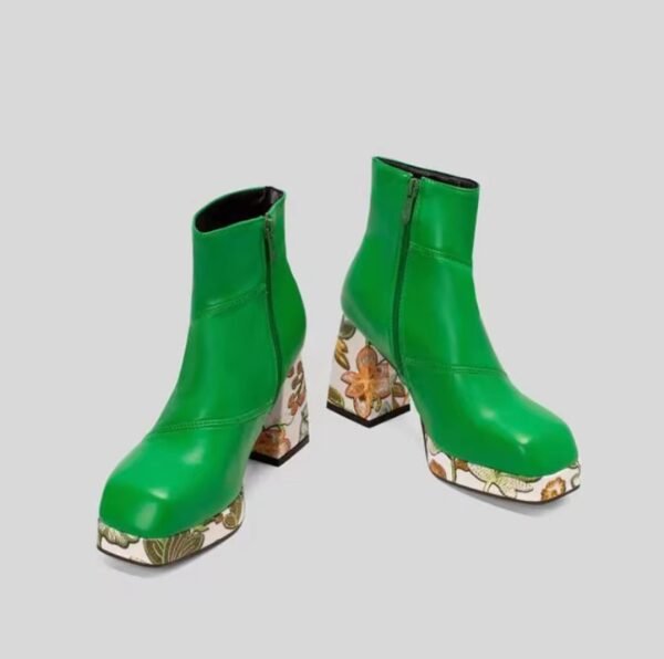 front view of green colorful Chelsea boots on the grey background