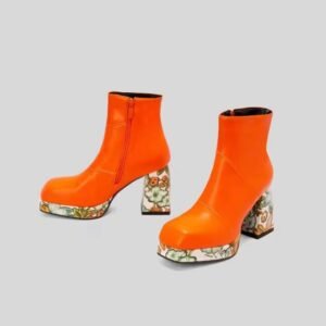 side and front view of orange colorful Chelsea boots on the grey background