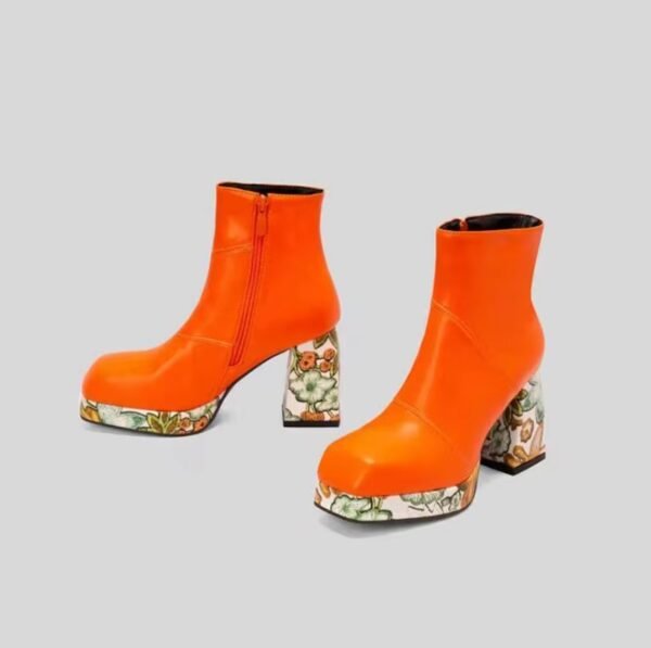 side and front view of orange colorful Chelsea boots on the grey background