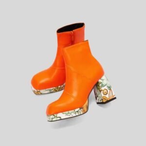 side view of orange colorful Chelsea boots on the grey background