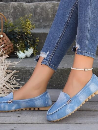 woman wearing colorful denim loafers, jeans and a white ankle bracelet