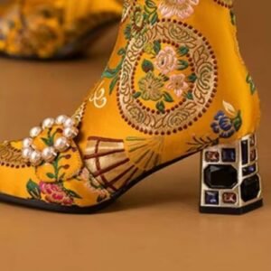 side view of colorful embroidery boots on the orange background