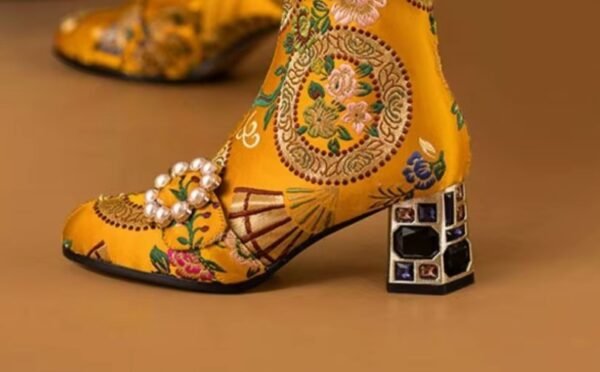 side view of colorful embroidery boots on the orange background