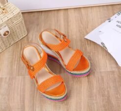 colorful summer wedges lying on a wooden floor, a piece of paper next to them