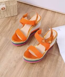 front view of colorful summer wedges on a wooden floor