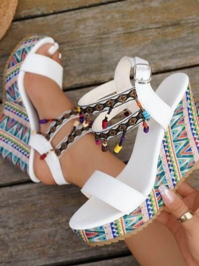 woman wearing one of colorful wedges shoes and holding the other one, wooden floor under her