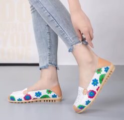 woman walking in floral colorful loafers and grey jeans