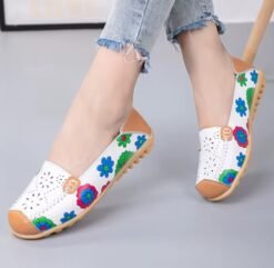 woman wearing floral colorful loafers and crossing her legs