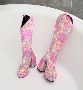 side view of long colorful boots lying on a white surface