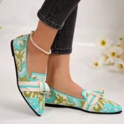 woman walking in multi colored loafers, white ankle bracelet and dark jeans