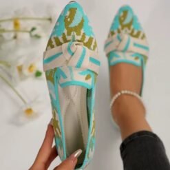 woman wearing one of multi colored loafers and wearing the other one