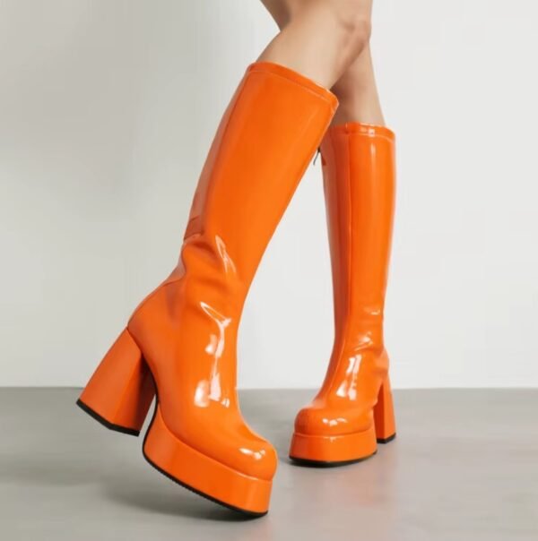 woman wearing orange boots on the grey floor, light grey wall in the background