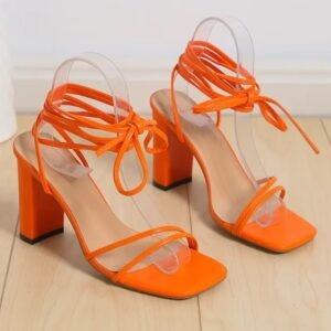 orange sandals lying on the wooden floor