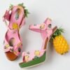 pineapple sandals lying on a white floor