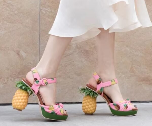 woman walking on the street wearing pineapple sandals and a white dress