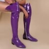 woman wearing purple boots on the beige backgorund