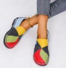 woman wearing women's colorful loafers and grey jeans on the white background