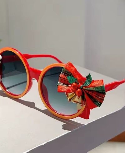 side view of colorful Christmas sunglasses on a white table
