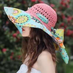 woman turned to her side wearing colorful beach hat and a white dress