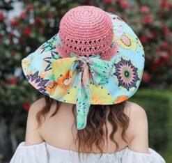 woman turned to her back wearing colorful beach hat and a white dress
