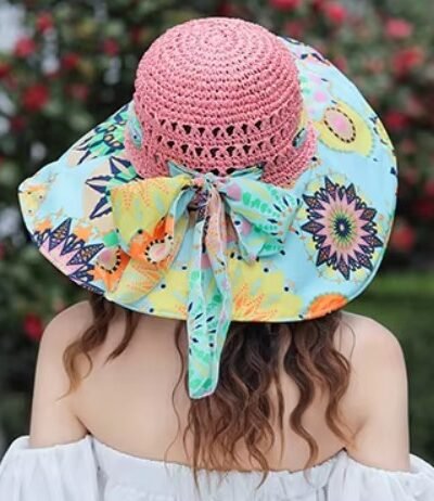 woman turned to her back wearing colorful beach hat and a white dress