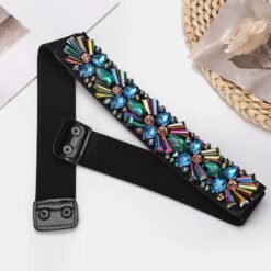 unzipped colorful belt with crystals lying on a white table